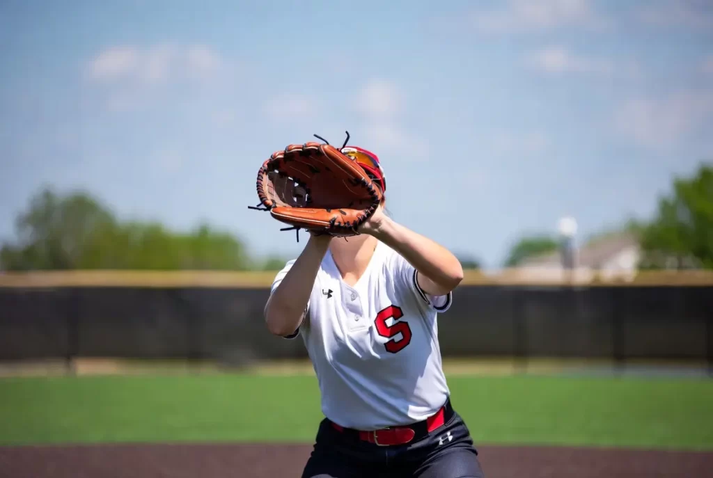 A softball player playing with a softball glove on the baseball field